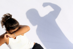women cowering on a white background with a shadow of a man shouting abuse